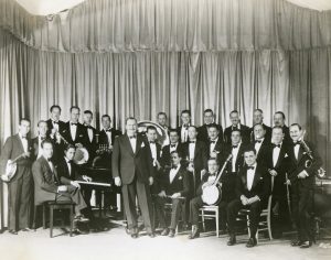 A group of musicians dressed in tuxedos, holding musical instruments.